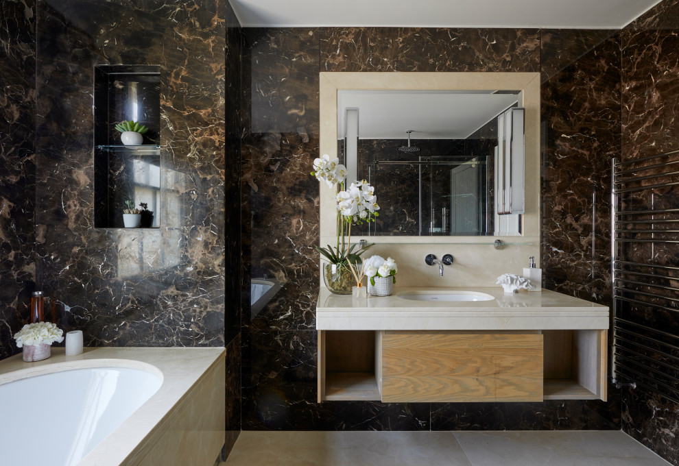 Inspiration for a large contemporary ensuite bathroom in London with flat-panel cabinets, beige cabinets, a built-in bath, a built-in shower, a one-piece toilet, beige tiles, grey walls, marble flooring, a built-in sink, marble worktops, grey floors, a sliding door, grey worktops, a feature wall, double sinks and a built in vanity unit.