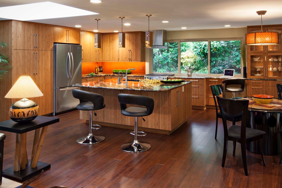 Design ideas for a large modern l-shaped open plan kitchen in Seattle with an undermount sink, flat-panel cabinets, medium wood cabinets, granite benchtops, orange splashback, bamboo floors and with island.