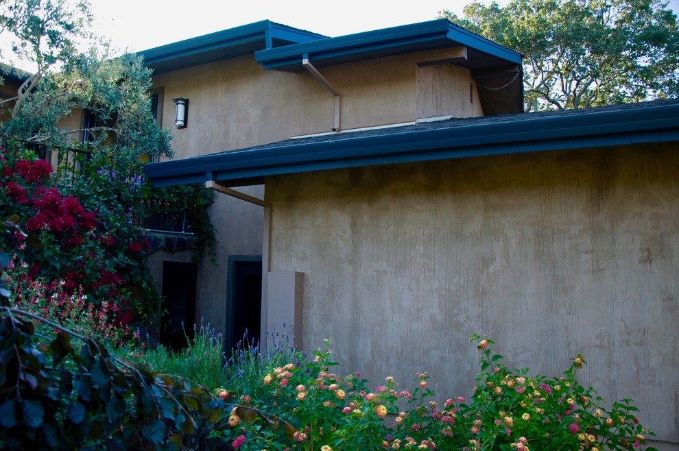 This is an example of an expansive traditional one-storey stucco beige house exterior in Other with a gable roof and a tile roof.