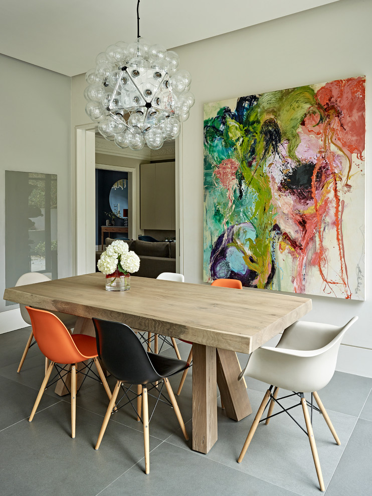 This is an example of a mid-sized contemporary separate dining room in London with light hardwood floors, beige walls and grey floor.