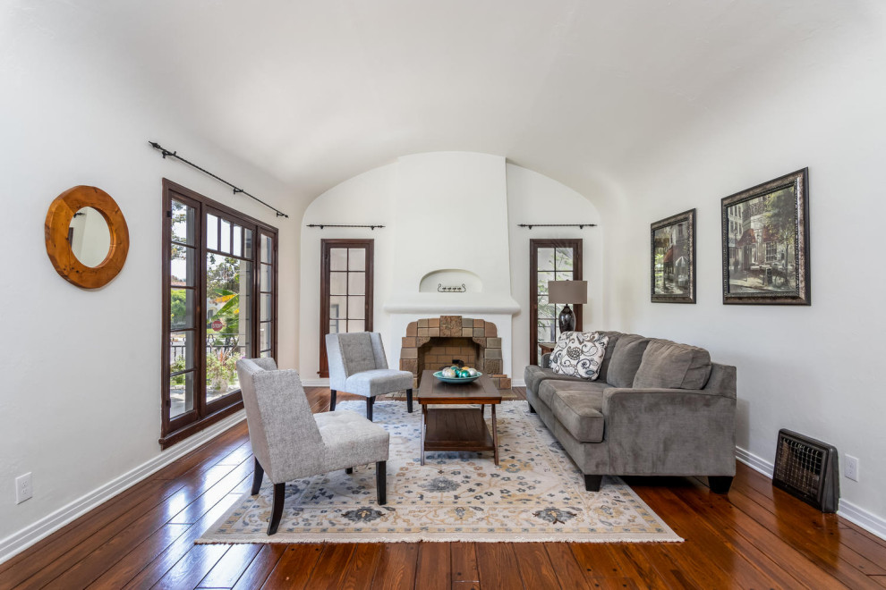 Photo of a mid-sized formal living room in Los Angeles with medium hardwood floors, a standard fireplace and a tile fireplace surround.