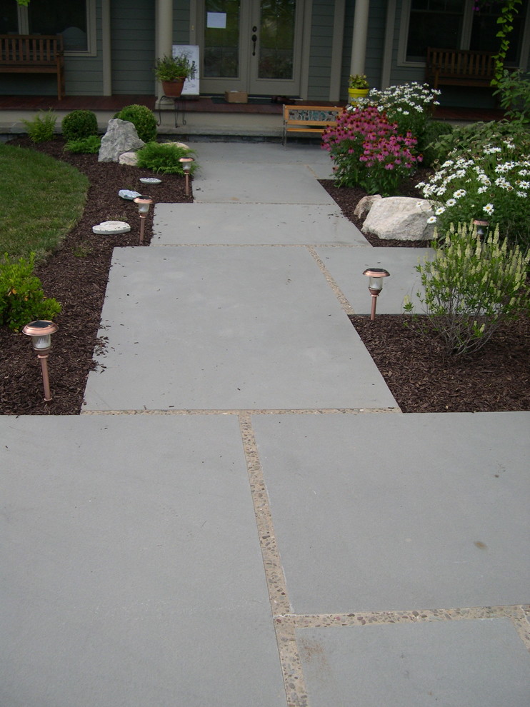 Inspiration for a mid-sized traditional front yard garden in New York with concrete pavers.