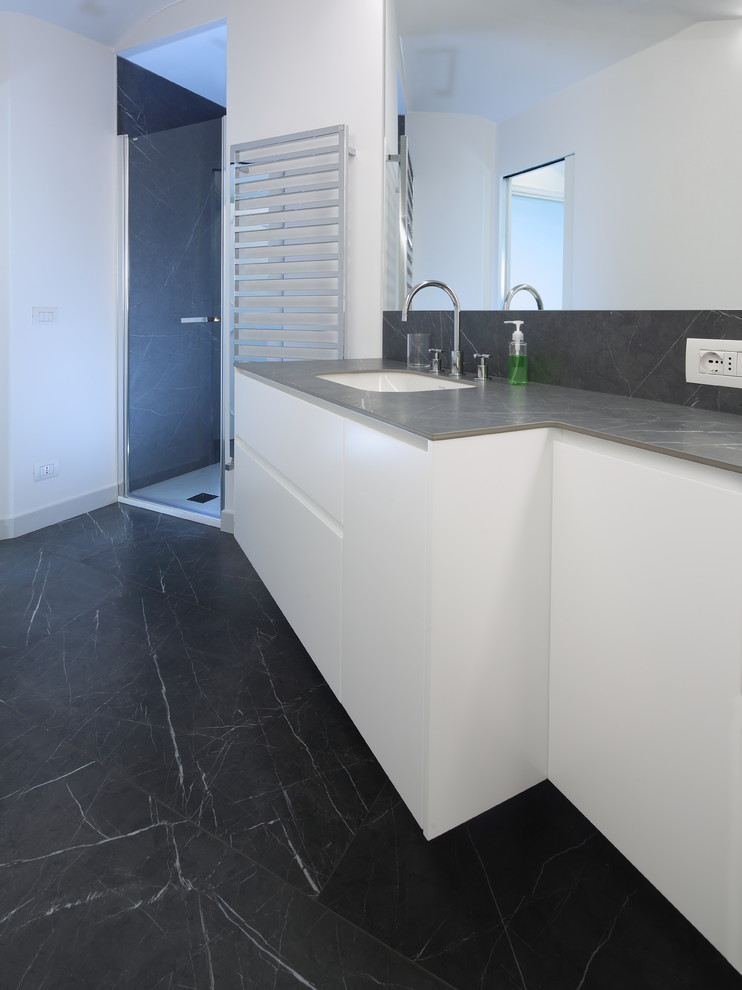 Modern bathroom in Other with gray tile, porcelain tile, white walls, porcelain floors, tile benchtops, grey floor, a hinged shower door and grey benchtops.
