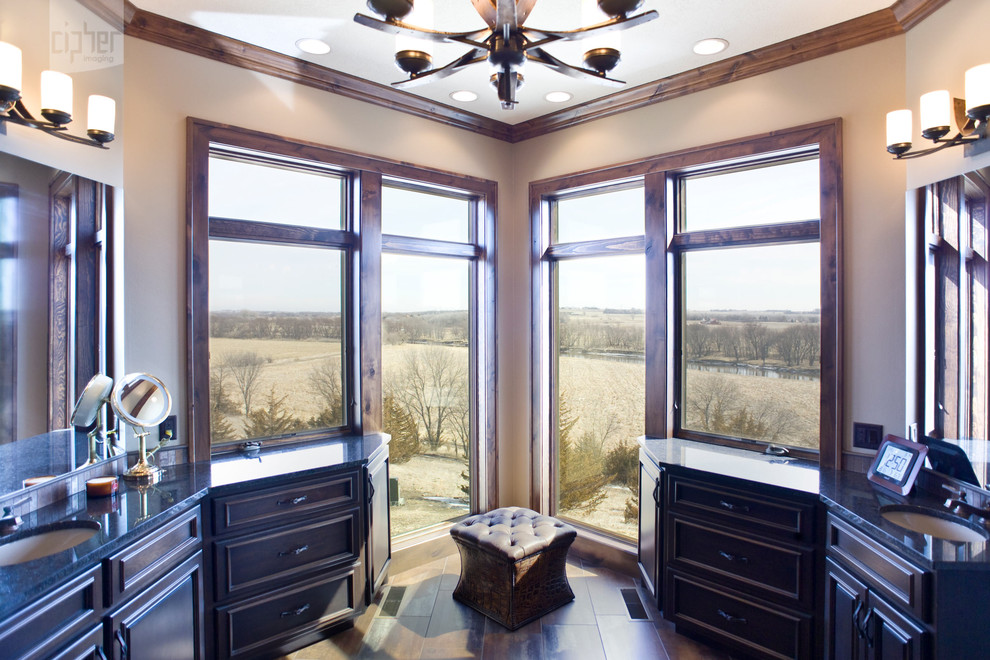 Mountain style master bathroom photo with an undermount sink, raised-panel cabinets, dark wood cabinets and beige walls