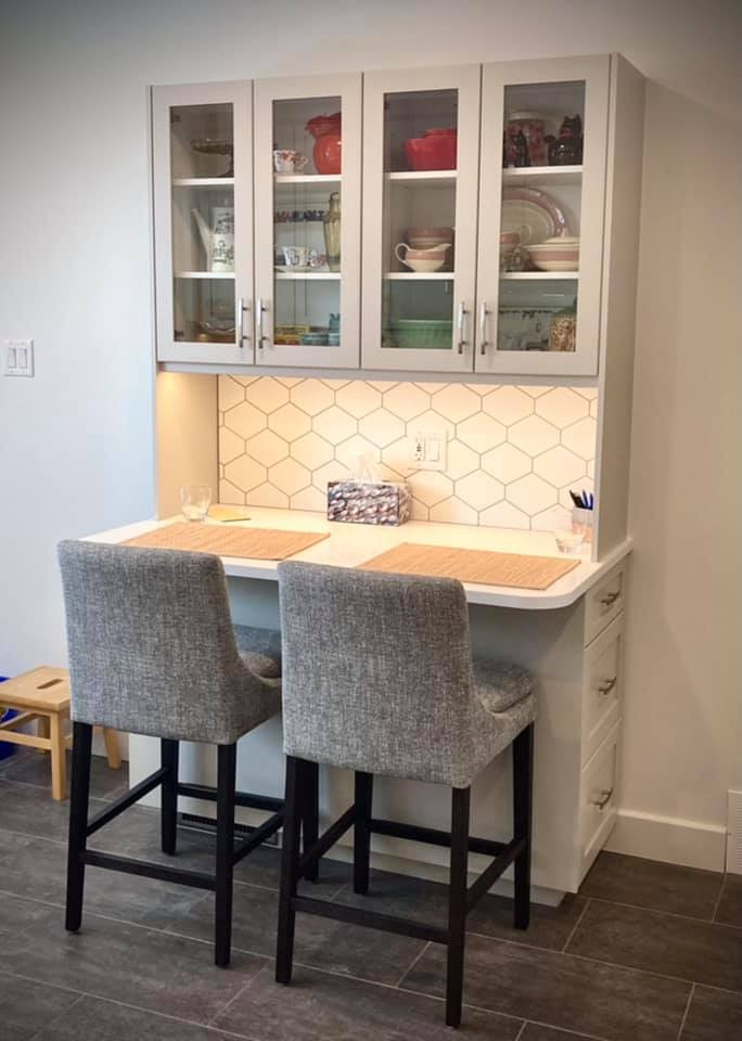 Mid-sized transitional u-shaped vinyl floor and gray floor enclosed kitchen photo with an undermount sink, shaker cabinets, beige cabinets, quartz countertops, white backsplash, ceramic backsplash, stainless steel appliances and white countertops