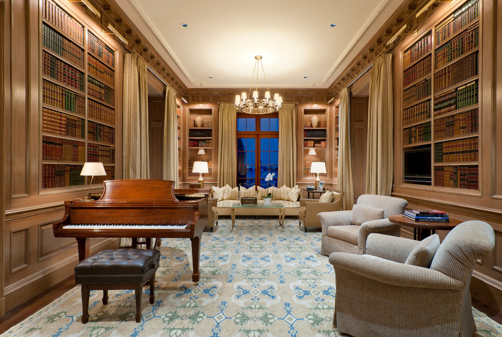 This is an example of a large traditional home office in Miami with brown walls, carpet and a library.