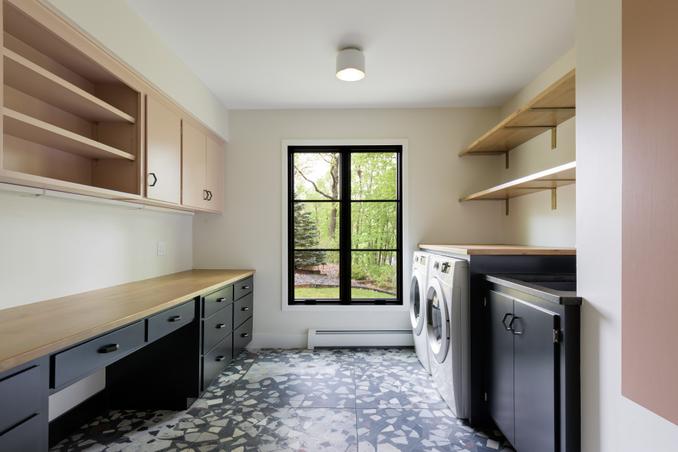 Inspiration for a large midcentury u-shaped laundry room in Minneapolis with an undermount sink, open cabinets, medium wood cabinets, granite benchtops, medium hardwood floors, brown floor and black benchtop.