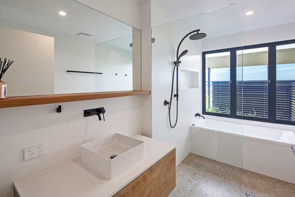 This is an example of a mid-sized contemporary bathroom in Other with light wood cabinets, a drop-in tub, an open shower, white tile, porcelain tile, concrete floors, engineered quartz benchtops, grey floor, an open shower and white benchtops.