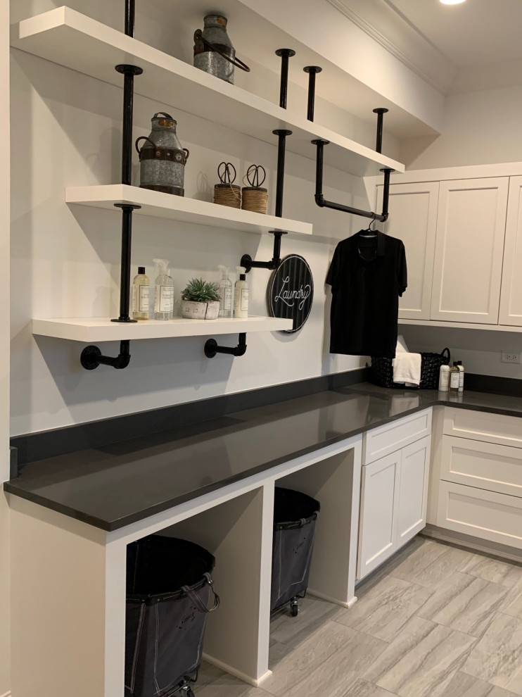 Photo of an industrial dedicated laundry room in Charlotte with shaker cabinets, white cabinets, quartzite benchtops, white walls, ceramic floors, an integrated washer and dryer and black benchtop.