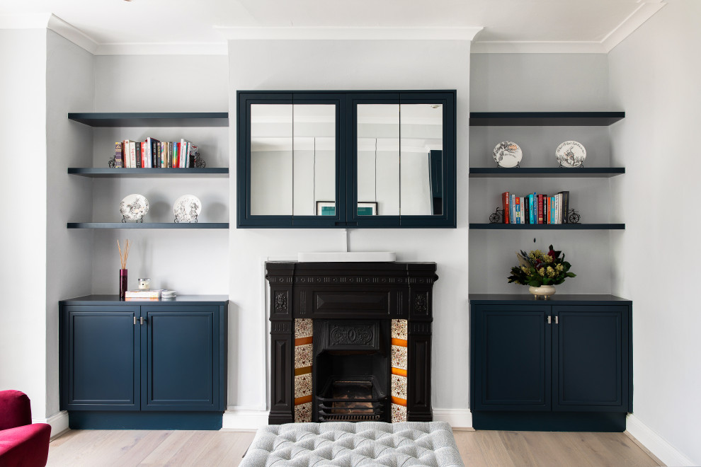 Réalisation d'un salon design de taille moyenne et fermé avec un mur bleu, un sol en bois brun, une cheminée standard, un manteau de cheminée en plâtre, un téléviseur fixé au mur et un sol gris.