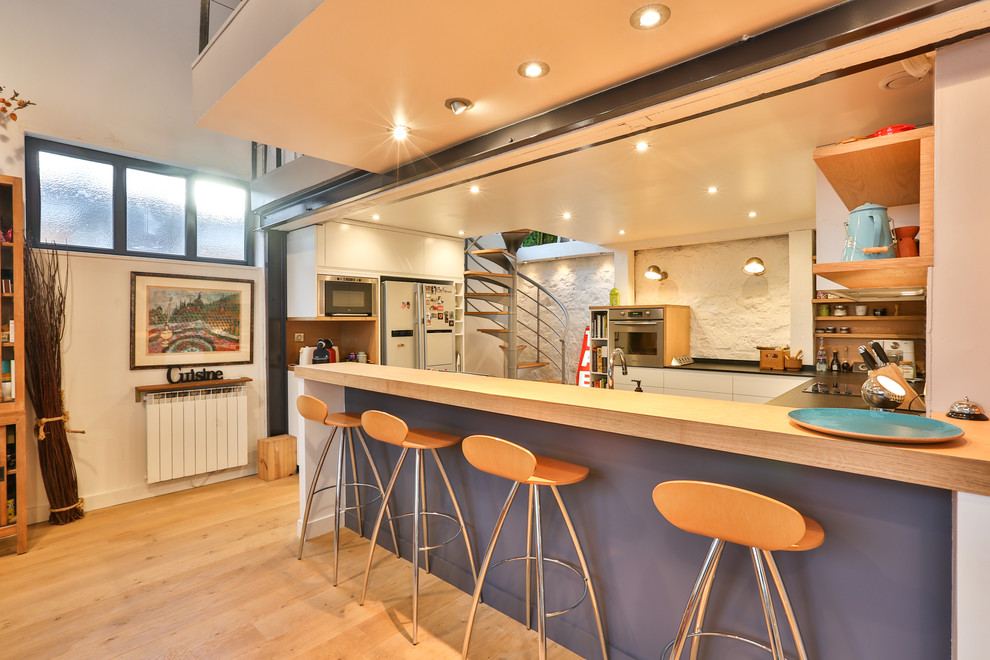 Mid-sized contemporary u-shaped eat-in kitchen in Grenoble with a single-bowl sink, beaded inset cabinets, white cabinets, marble benchtops, grey splashback, cement tile splashback, stainless steel appliances, concrete floors and no island.