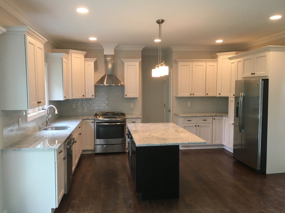 Mid-sized transitional u-shaped dark wood floor and brown floor kitchen photo in New York with an undermount sink, flat-panel cabinets, white cabinets, quartz countertops, gray backsplash, glass tile backsplash, stainless steel appliances, an island and white countertops