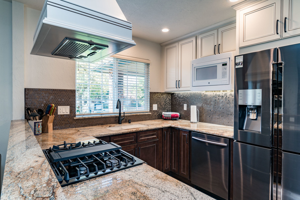 Inspiration for a mid-sized transitional u-shaped medium tone wood floor and brown floor eat-in kitchen remodel with an undermount sink, recessed-panel cabinets, white cabinets, granite countertops, brown backsplash, mosaic tile backsplash, stainless steel appliances and no island