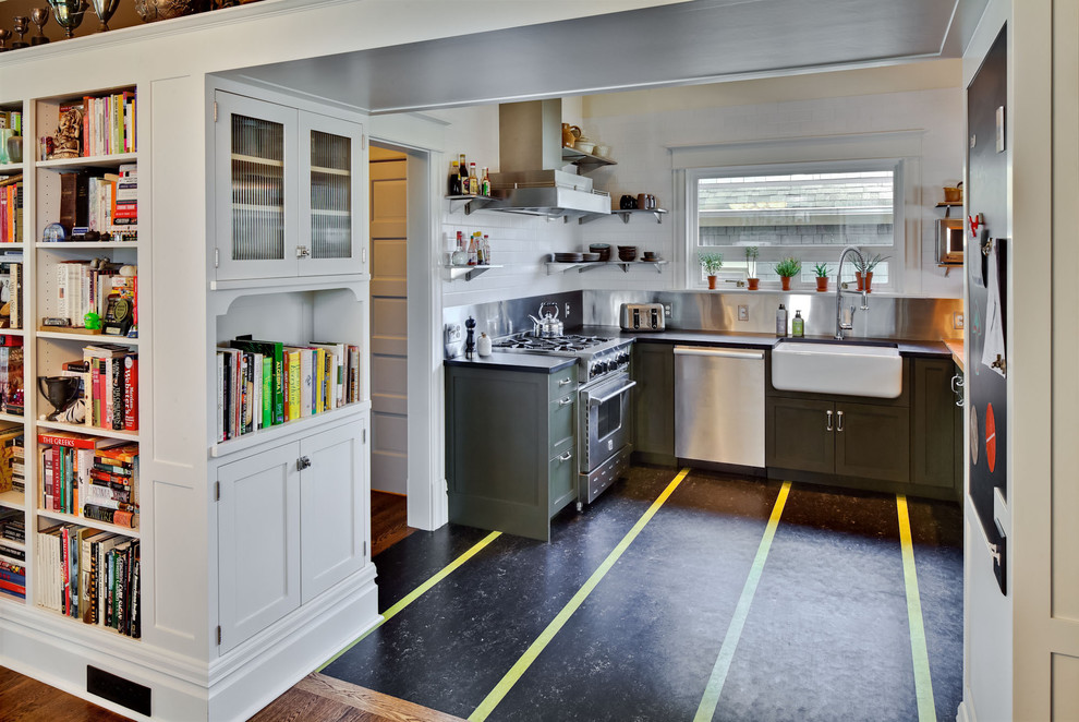 Photo of a transitional kitchen in Seattle with a farmhouse sink, green cabinets, metallic splashback, metal splashback and stainless steel appliances.