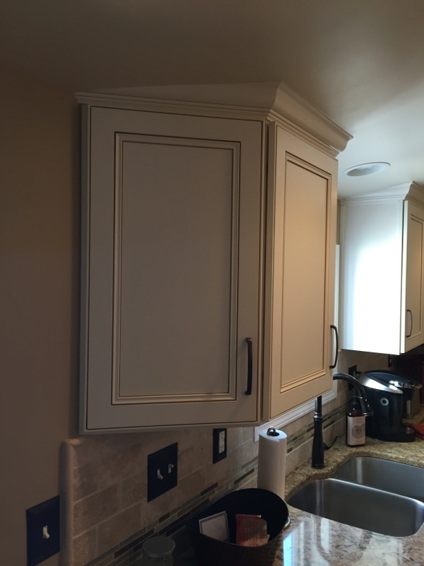 Example of a mid-sized transitional u-shaped medium tone wood floor home design design with an undermount sink, flat-panel cabinets, dark wood cabinets, quartz countertops, beige backsplash, stone tile backsplash, stainless steel appliances and an island