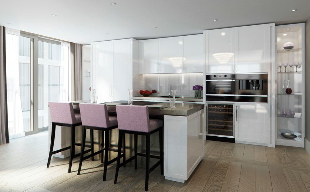 Contemporary galley open plan kitchen in London with an undermount sink, shaker cabinets, white cabinets, glass sheet splashback, panelled appliances, light hardwood floors and with island.