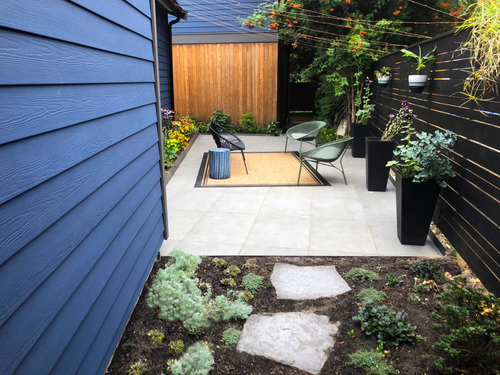 Modelo de patio contemporáneo en patio lateral con suelo de baldosas