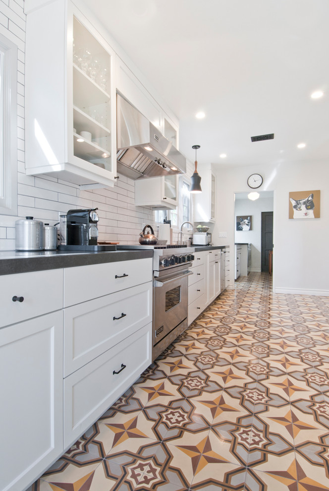 Mid-sized transitional galley eat-in kitchen in Los Angeles with an undermount sink, shaker cabinets, white cabinets, quartzite benchtops, white splashback, ceramic splashback, stainless steel appliances, cement tiles, with island and yellow floor.