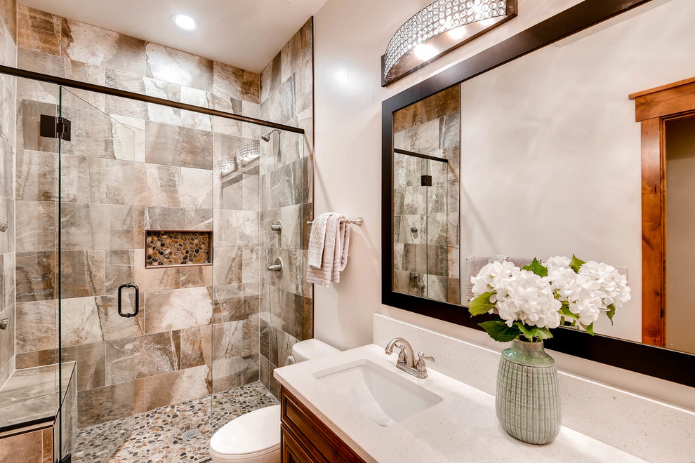 Mid-sized arts and crafts 3/4 bathroom in Denver with raised-panel cabinets, dark wood cabinets, an alcove shower, a one-piece toilet, beige tile, ceramic tile, beige walls, an undermount sink, terrazzo benchtops, a hinged shower door, white benchtops and beige floor.