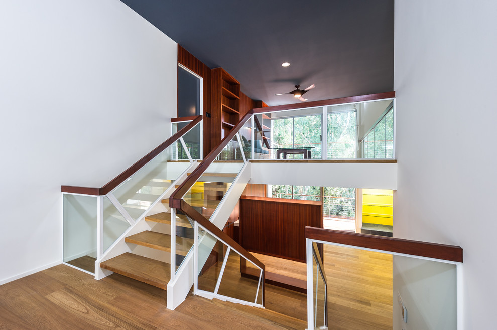 Inspiration for a large midcentury wood u-shaped staircase in Los Angeles with open risers.