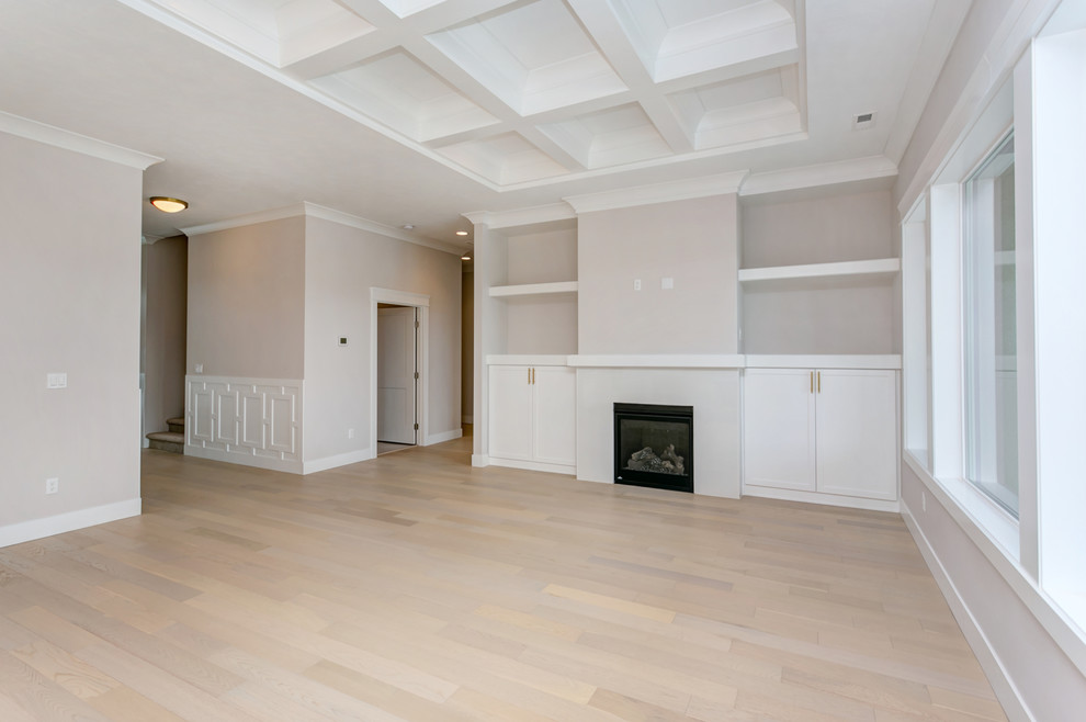 This is an example of a mid-sized transitional open concept living room in Seattle with grey walls, light hardwood floors, a standard fireplace, a tile fireplace surround and a built-in media wall.