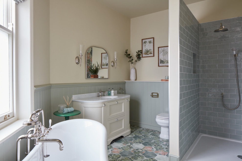 Inspiration for a farmhouse bathroom in Other with recessed-panel cabinets, beige cabinets, a freestanding bath, grey tiles, metro tiles, beige walls, a submerged sink, multi-coloured floors, an open shower, white worktops, a single sink and a freestanding vanity unit.