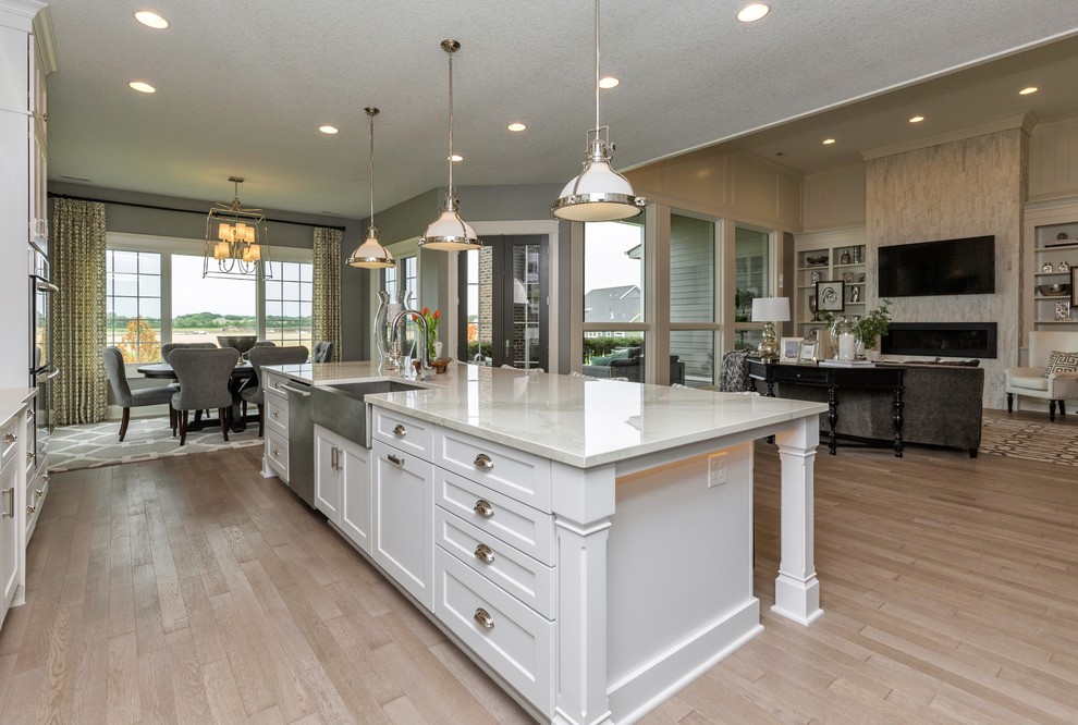 This is an example of a large transitional l-shaped eat-in kitchen in Other with a farmhouse sink, shaker cabinets, white cabinets, marble benchtops, stainless steel appliances, porcelain floors and with island.