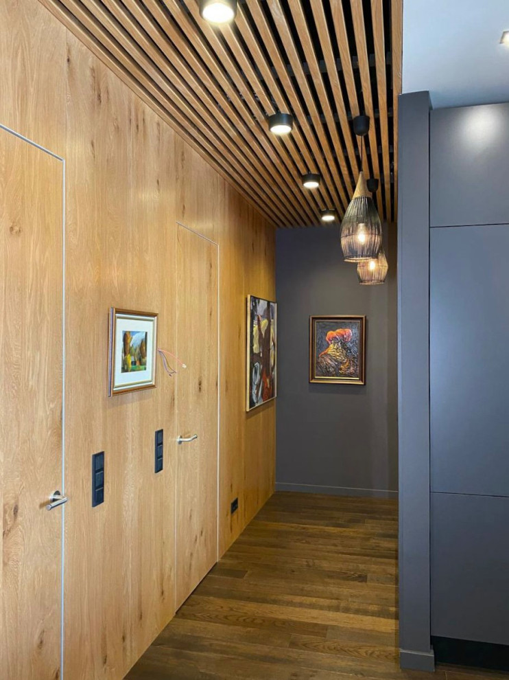 Скрытые двери в одном стиле со стеновыми панелями и реечное обрамление потолка