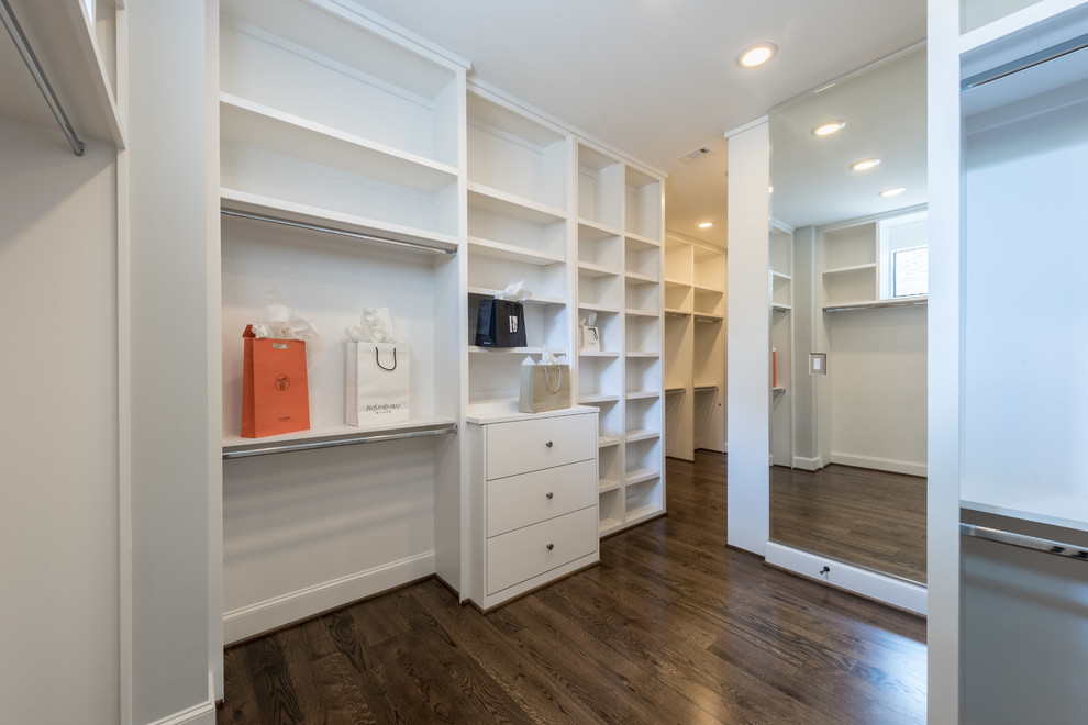 This is an example of a large transitional gender-neutral walk-in wardrobe in Houston with flat-panel cabinets, grey cabinets and medium hardwood floors.