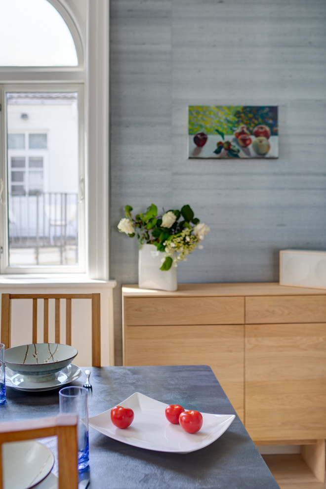 Imagen de comedor nórdico grande abierto con paredes metalizadas, suelo de madera clara y papel pintado