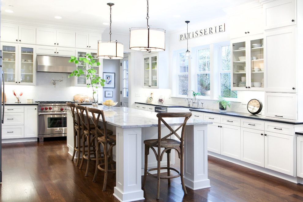 Inspiration for a traditional u-shaped eat-in kitchen in Portland with a farmhouse sink, shaker cabinets, white cabinets, quartzite benchtops, white splashback, subway tile splashback and stainless steel appliances.