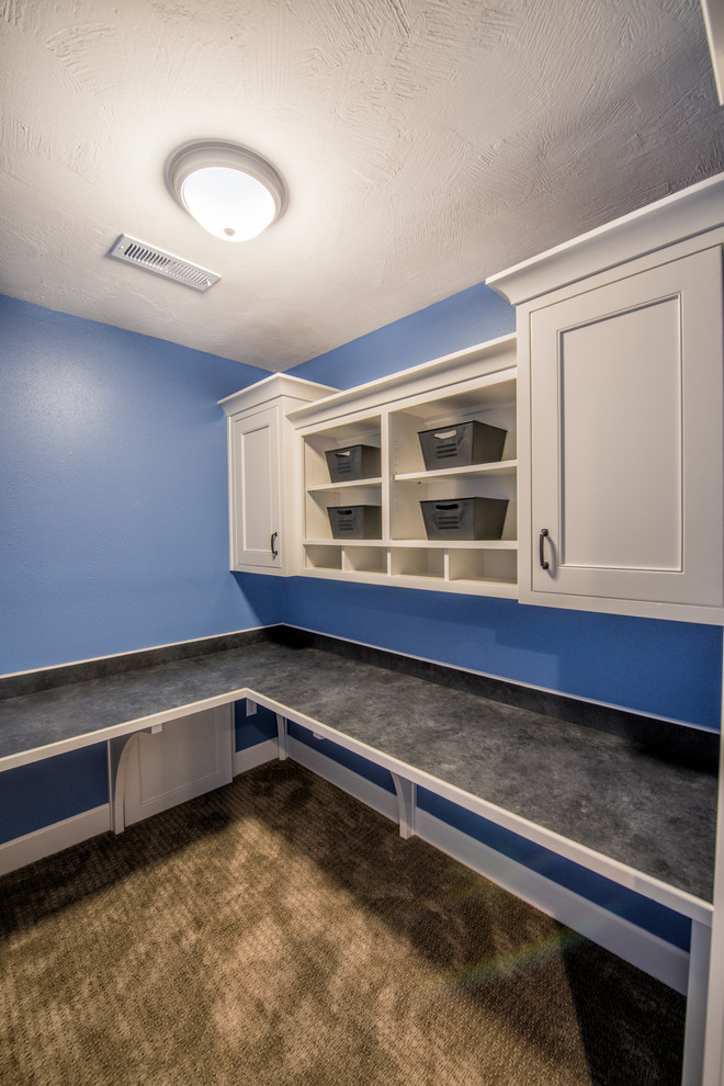Inspiration for a large modern l-shaped utility room in Other with white cabinets, blue walls, carpet, brown floor and recessed-panel cabinets.