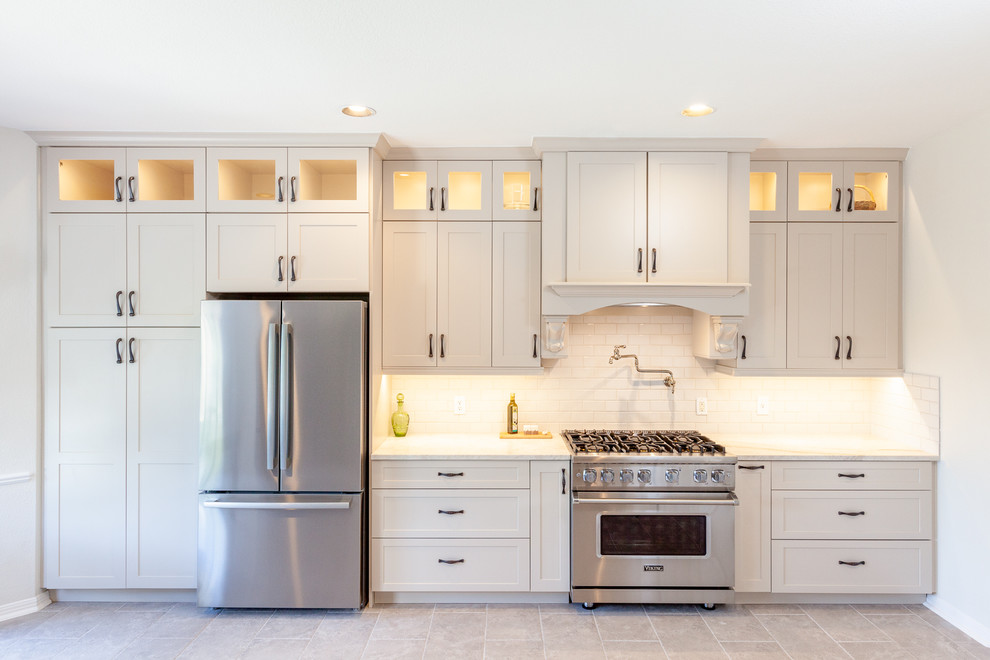 Eat-in kitchen - large transitional galley beige floor eat-in kitchen idea in Austin with an undermount sink, white backsplash, subway tile backsplash, stainless steel appliances, shaker cabinets, beige cabinets, marble countertops, two islands and white countertops