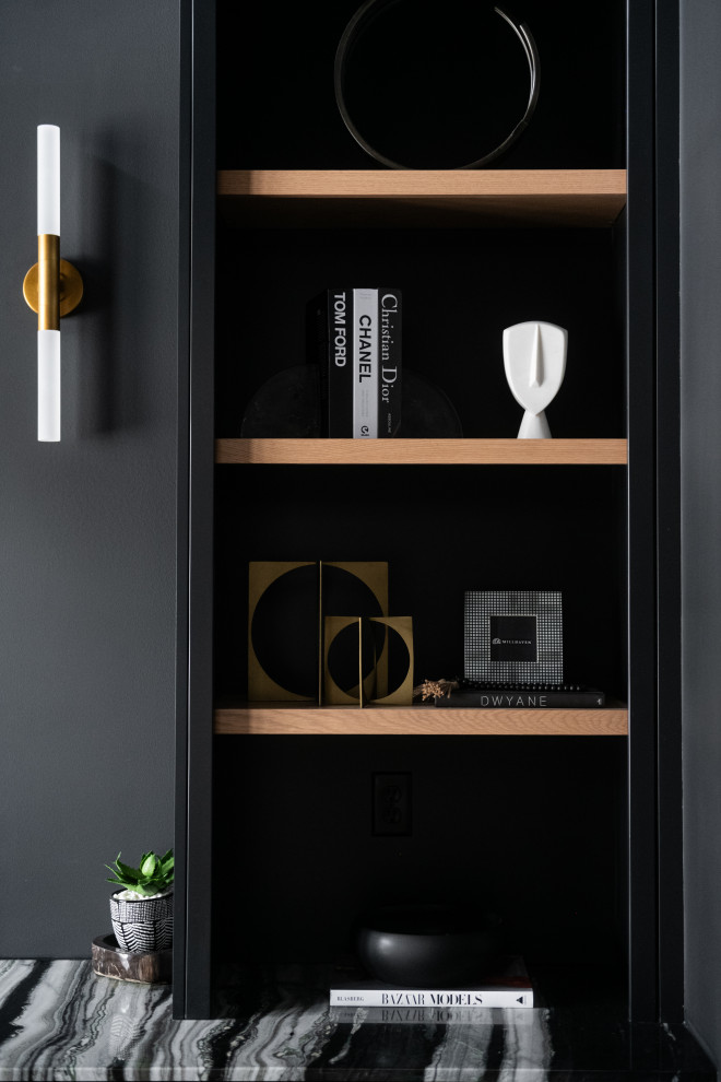 Cette image montre un bureau minimaliste de taille moyenne avec un mur noir, parquet clair, un bureau intégré et un sol marron.
