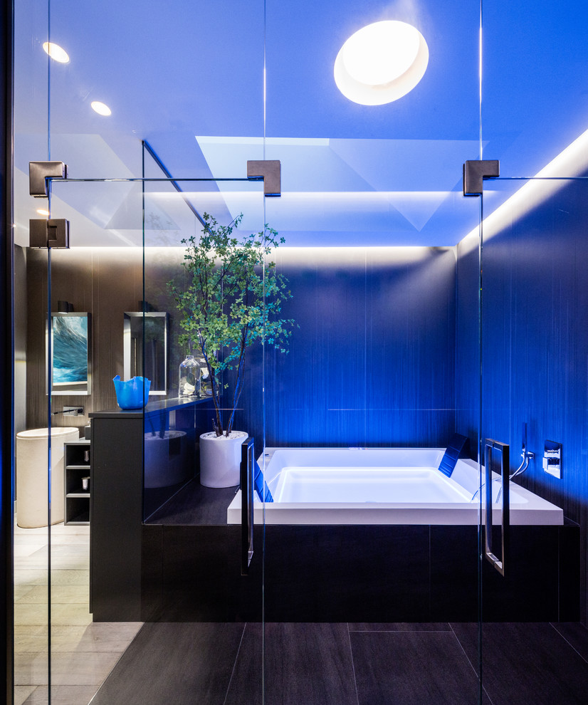 Inspiration for an expansive eclectic master bathroom in Milan with raised-panel cabinets, black cabinets, a hot tub, an open shower, a wall-mount toilet, black tile, porcelain tile, black walls, dark hardwood floors, a pedestal sink, limestone benchtops, grey floor and a sliding shower screen.