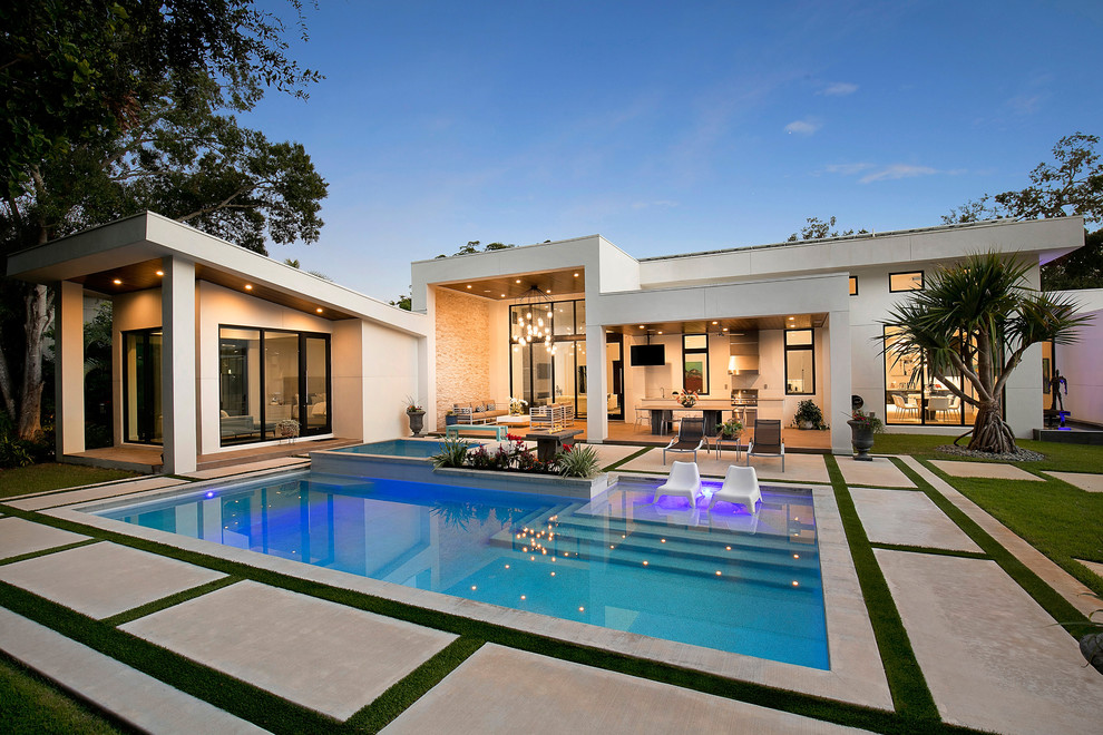 Contemporary backyard rectangular pool in Tampa with a pool house and concrete slab.