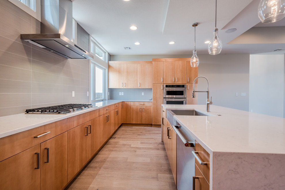 Eat-in kitchen - large transitional u-shaped dark wood floor eat-in kitchen idea with a farmhouse sink, flat-panel cabinets, light wood cabinets, quartz countertops, gray backsplash, subway tile backsplash, stainless steel appliances and an island