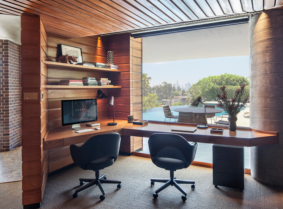 This is an example of a midcentury study room with brown walls, carpet, a built-in desk, grey floor, no fireplace, wood and wood walls.