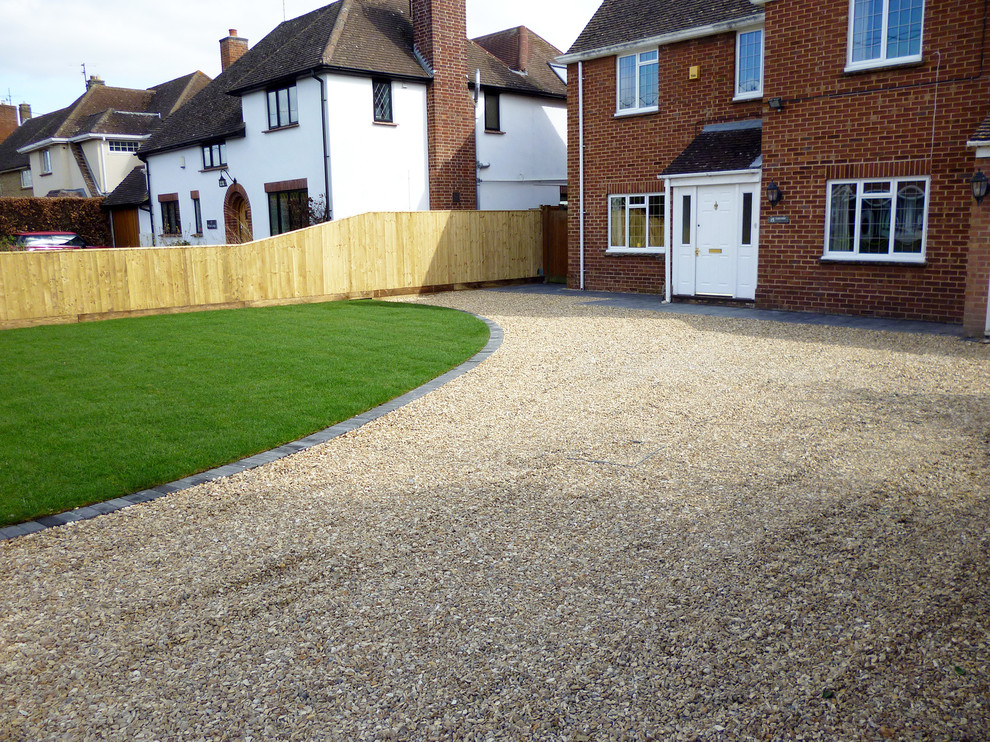 Design ideas for a large modern front yard partial sun driveway for summer in Oxfordshire with gravel.