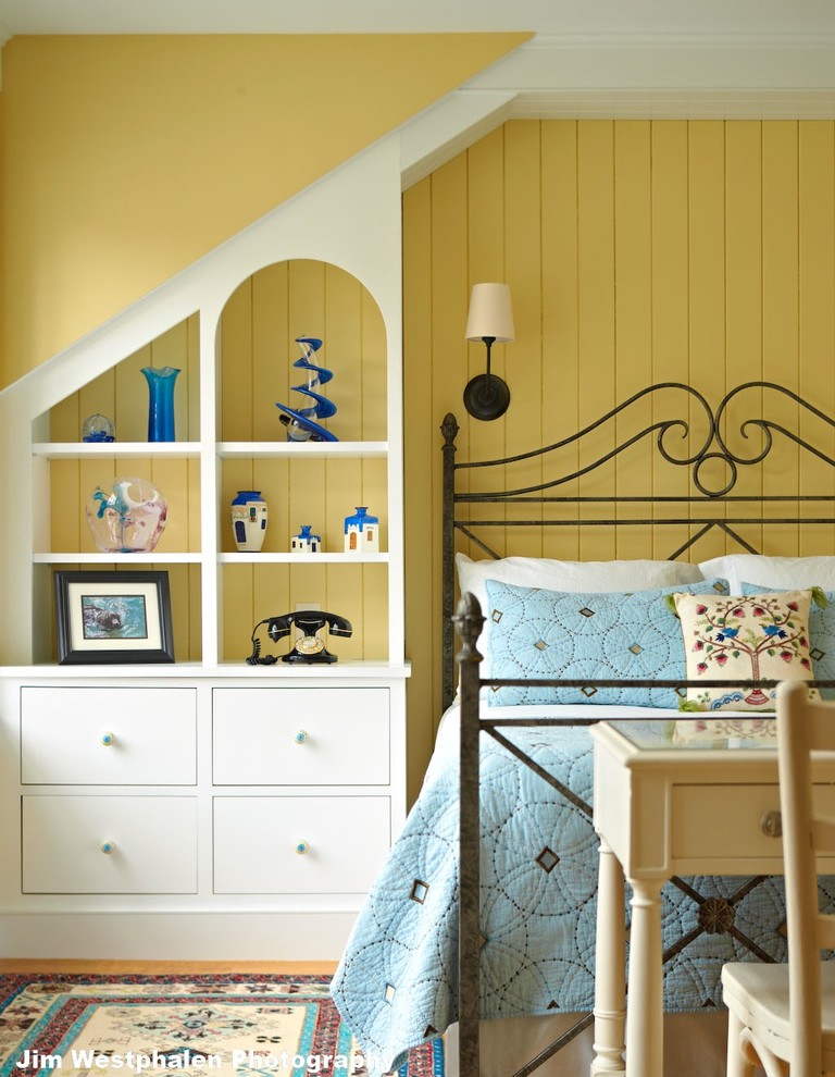 This is an example of a mid-sized traditional guest bedroom in Burlington with yellow walls and light hardwood floors.
