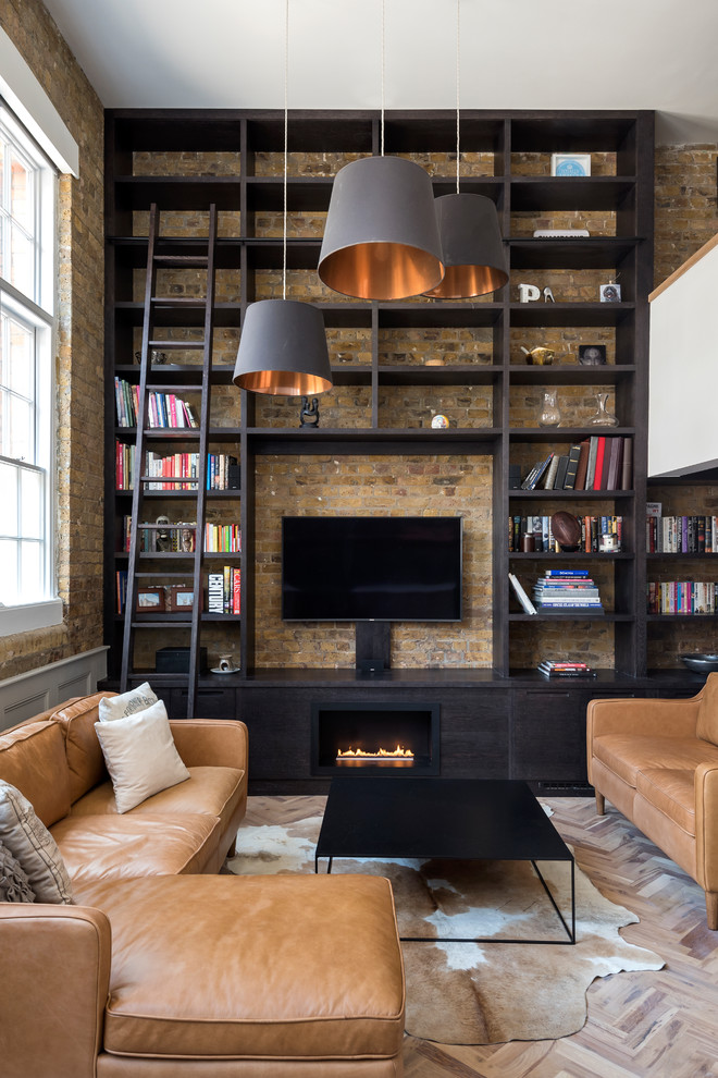 Design ideas for a mid-sized industrial open concept living room in London with beige walls, light hardwood floors, a ribbon fireplace, a wood fireplace surround, a wall-mounted tv and brown floor.