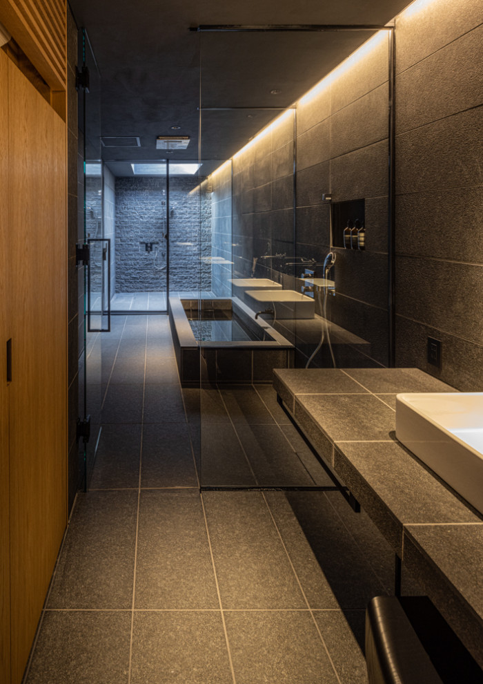 Inspiration for a modern bathroom in Kobe with open cabinets, black cabinets, a hot tub, a double shower, black tiles, porcelain tiles, black walls, porcelain flooring, a vessel sink, tiled worktops, black floors, an open shower, white worktops, a wall niche, double sinks and a built in vanity unit.