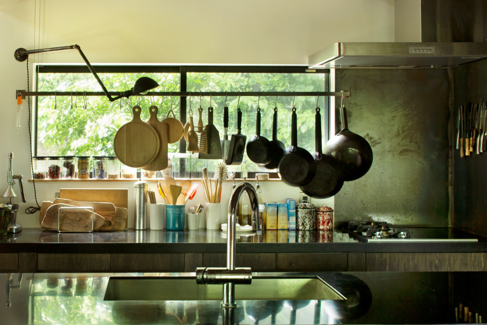 Idéer för ett mellanstort modernt svart kök, med en undermonterad diskho, luckor med profilerade fronter, svarta skåp, bänkskiva i koppar, svart stänkskydd, svarta vitvaror, betonggolv, en köksö och grått golv