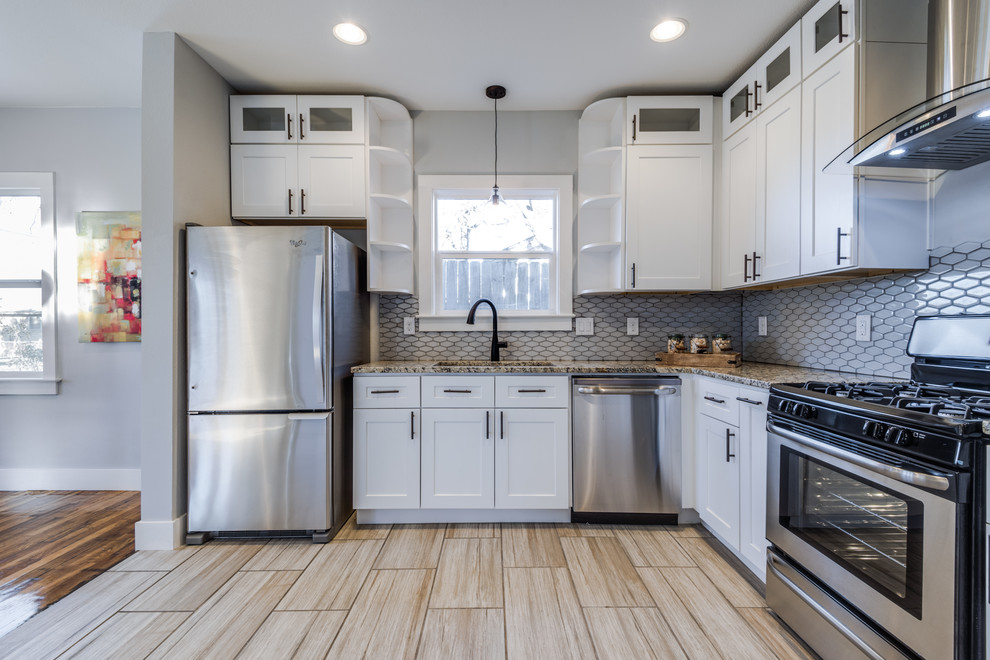 Photo of a small transitional u-shaped eat-in kitchen in Austin with an undermount sink, shaker cabinets, white cabinets, granite benchtops, white splashback, mosaic tile splashback, stainless steel appliances, porcelain floors and no island.