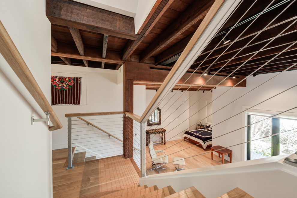 This is an example of a mid-sized contemporary look-out basement in San Francisco with white walls, light hardwood floors and multi-coloured floor.