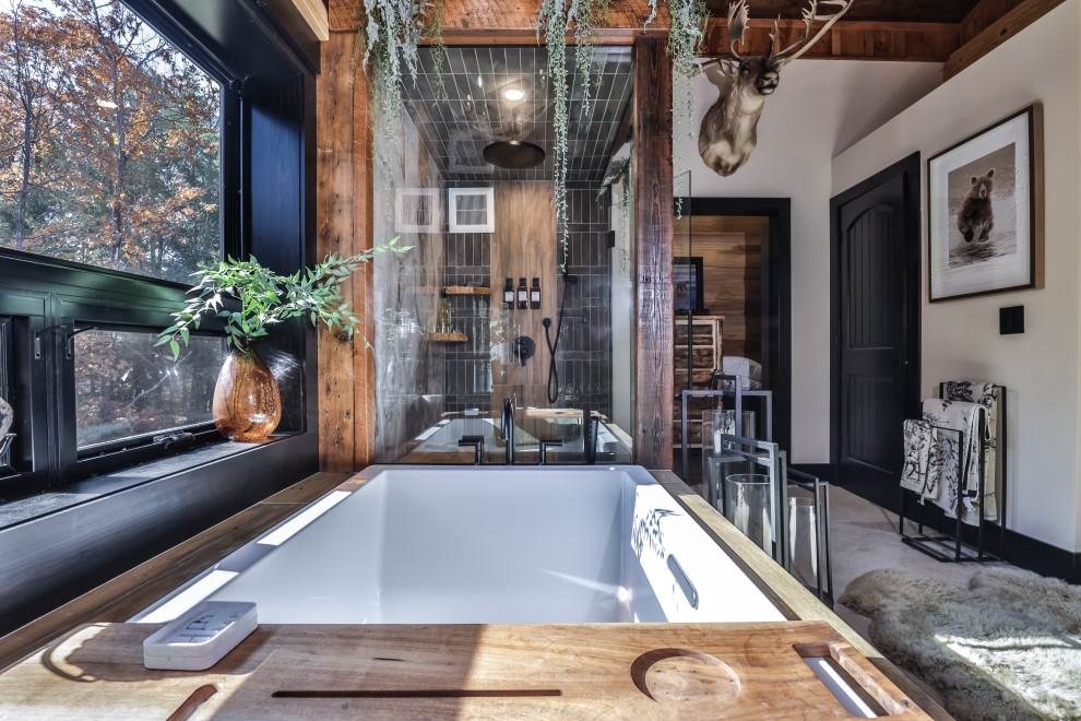 Mid-sized mountain style master slate floor, gray floor and exposed beam drop-in bathtub photo with a hinged shower door