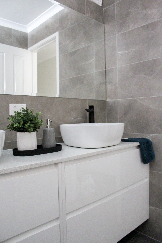 This is an example of a mid-sized modern kids bathroom in Perth with flat-panel cabinets, white cabinets, an open shower, gray tile, porcelain tile, engineered quartz benchtops, an open shower, white benchtops, a single vanity and a floating vanity.