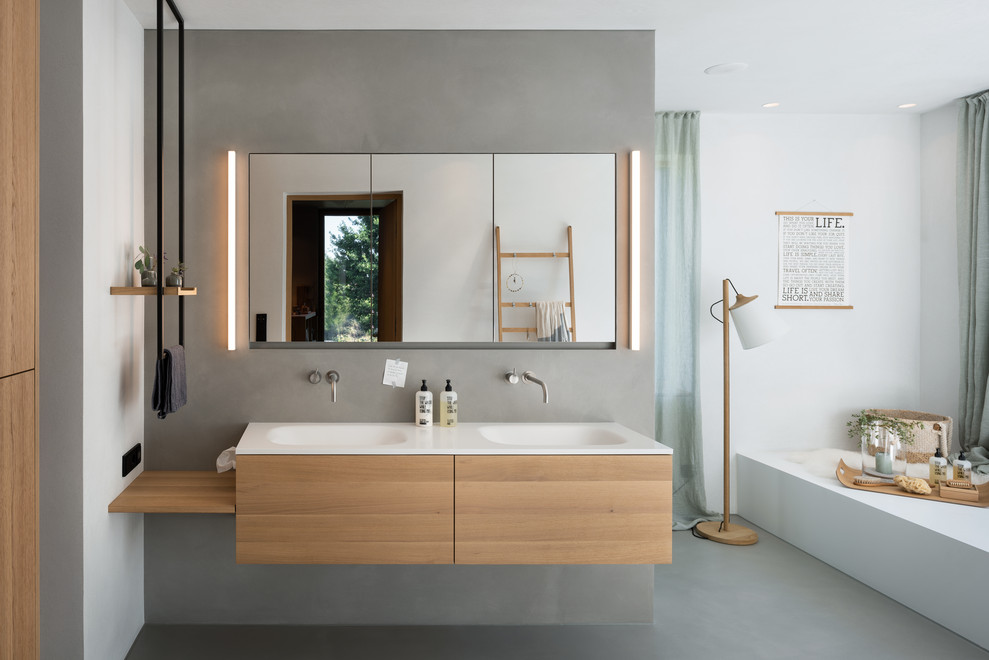 Expansive scandinavian master bathroom in Munich with grey walls, concrete floors, an integrated sink, grey floor, flat-panel cabinets, light wood cabinets, white benchtops, a double vanity and a floating vanity.
