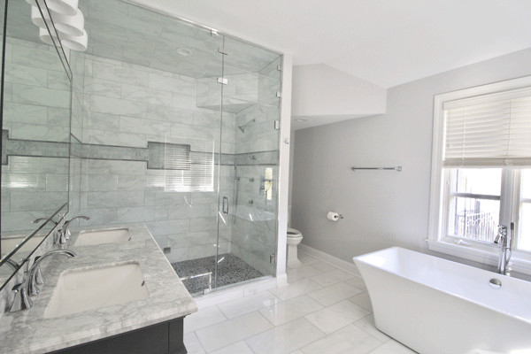 Design ideas for a large transitional 3/4 bathroom in Philadelphia with a freestanding tub, gray tile, marble, grey walls, grey floor, shaker cabinets, dark wood cabinets, an alcove shower, a two-piece toilet, marble floors, an undermount sink, marble benchtops and a hinged shower door.