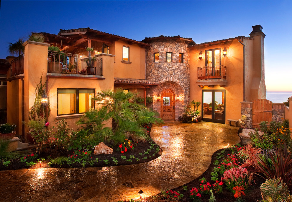 This is an example of a mid-sized mediterranean two-storey stucco brown exterior in San Luis Obispo with a gable roof.